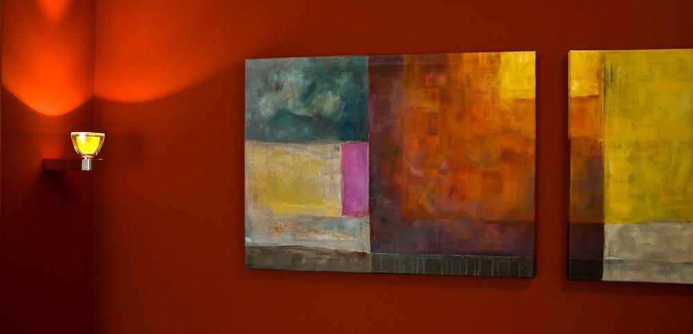 Rote Wand mit Wandleuchte und Bildern